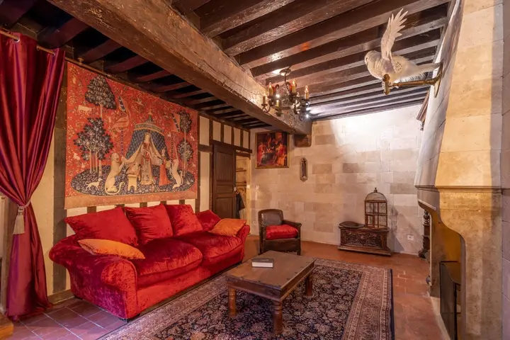 Le canapé rouge et la tapisserie murale