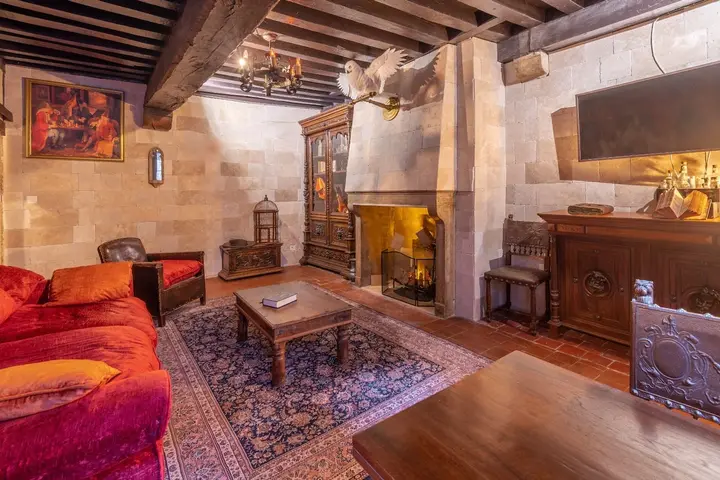 Le salon en pierre apparente avec sa cheminée