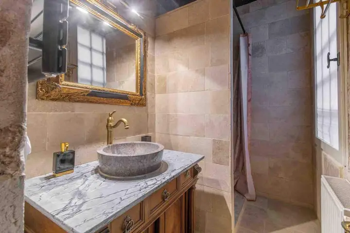 La salle de bain et sa vasque de pierre